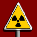 Signe Radioactif dans un panneau danger sur fond rouge